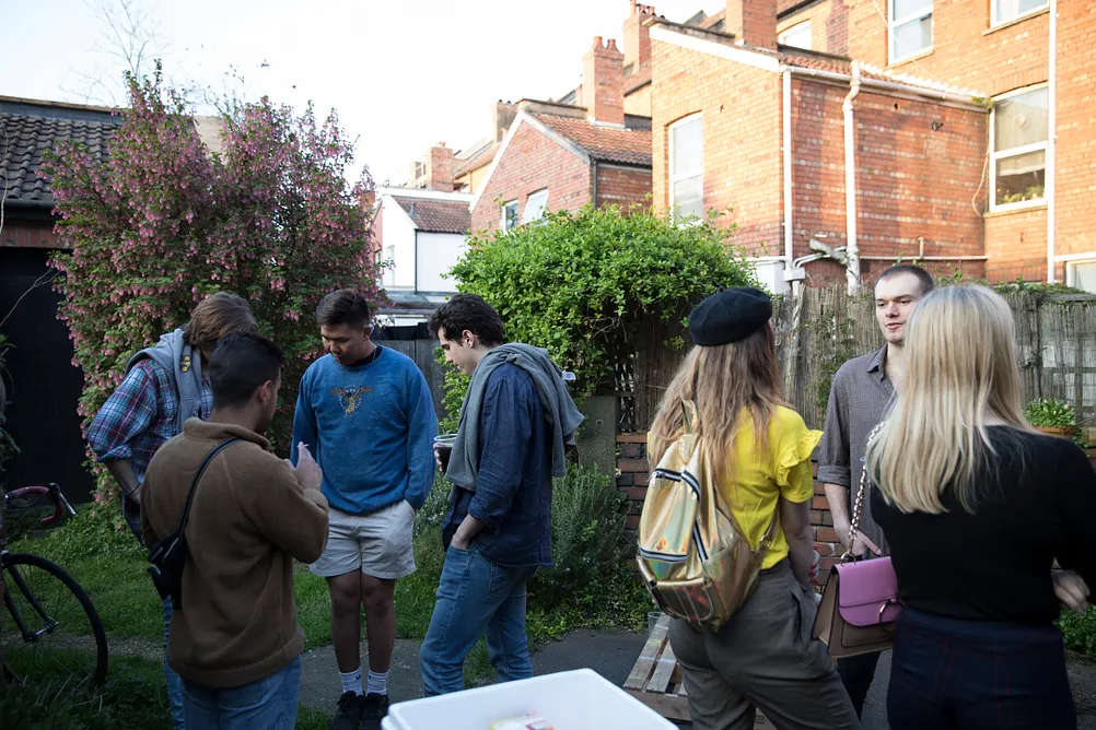 A group of visitors gathered in the garden where the exhibition is taking place