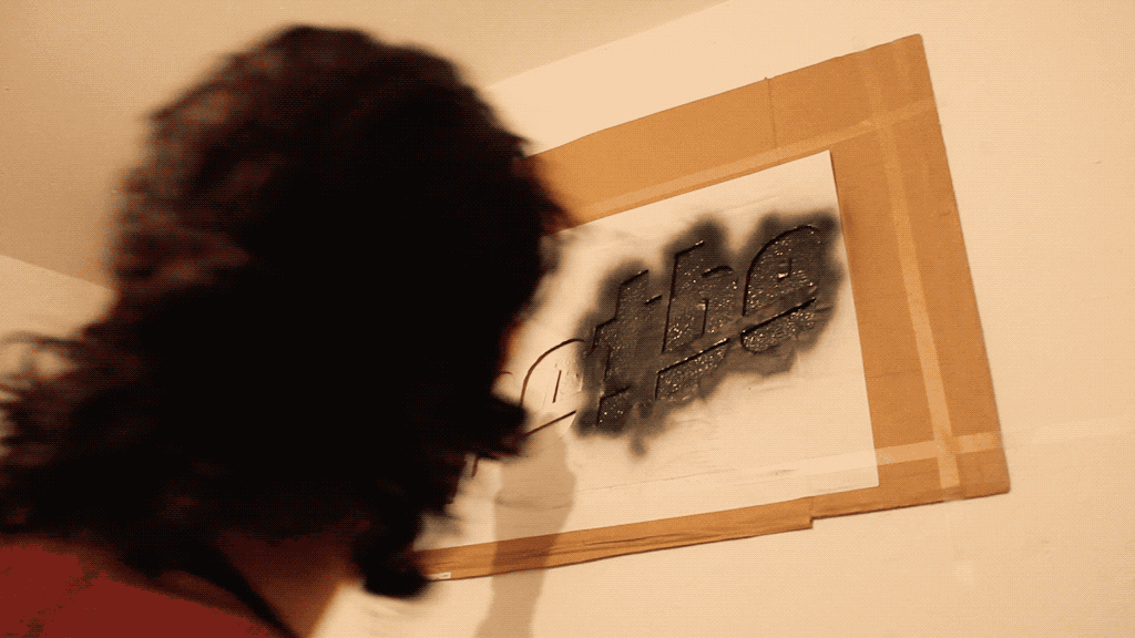 Spray-painting the _hotbe_ stencil onto the wall